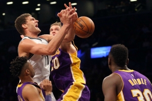 Brooklyn Nets center Brook Lopez fouled as he drives by Lakers center Timofey Mozgov at Barclays Center on December 14, 2016. 