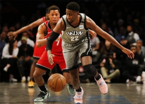 Brooklyn Nets guard, Caris LeVert, defends ball against Toronto Raptors guard, Kyle Lowry (in the background), at the Barclays Center in Brooklyn, NY on February 12, 2020.