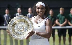 Serena Williams holding trophy after defeating Garbine Muguruza 6-4, 6-4